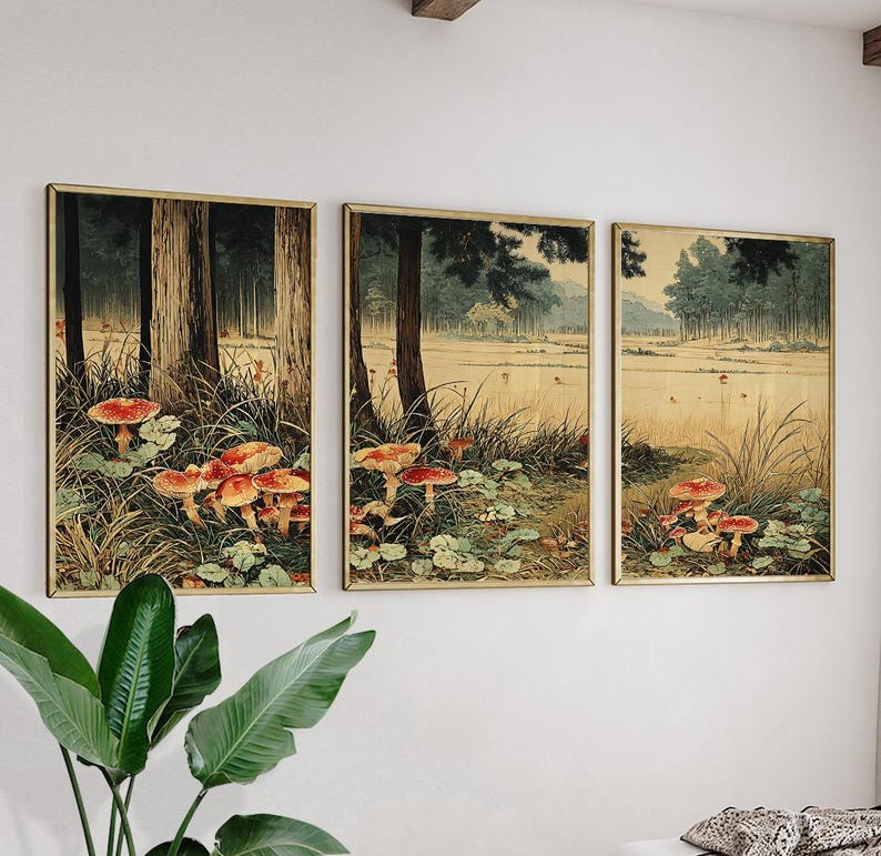 May include: Three framed art prints depicting a forest scene with red-capped mushrooms. The artwork has a vintage aesthetic, with tall trees, grassy areas, and a soft, natural colour palette. The frames are gold-toned.