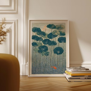 May include: Framed art print featuring a serene pond scene with teal lily pads and a vibrant orange koi fish. The artwork has a vintage aesthetic, with a textured appearance and a soft color palette. The print is displayed in a white frame.