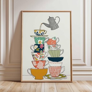 May include: A framed art print featuring a whimsical illustration of a tower of teacups. The teacups are stacked high, with a teapot pouring tea into the top cup. The teacups are decorated with floral and geometric patterns in various colors.