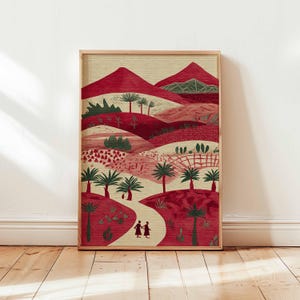 May include: A framed art print depicting a stylized landscape with red hills, palm trees, and a winding path. Two figures walk on the path. The artwork uses a warm palette of reds, greens, and beige, and is presented in a wooden frame.