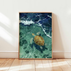 Puede incluir: Una impresión artística enmarcada que representa una tortuga marina nadando en agua turquesa. La tortuga tiene un caparazón amarillo y marrón. La obra de arte está enmarcada en un marco de madera marrón claro.