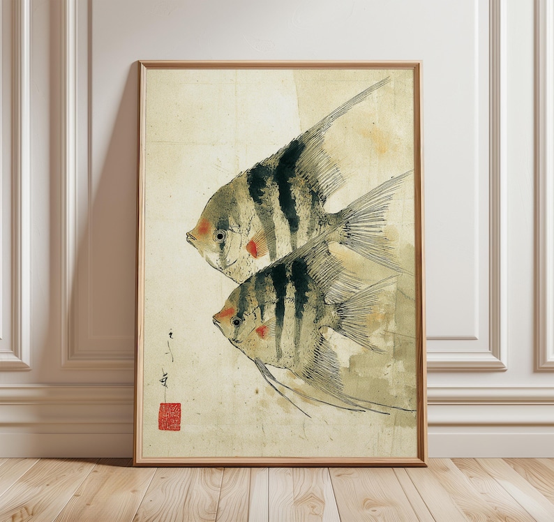K&ouml;nnte beinhalten: Gerahmter Kunstdruck mit zwei stilisierten Fischen mit schwarz-wei&szlig;en Streifen, roten Akzenten und langen Flossen. Das Kunstwerk hat eine Vintage-&Auml;sthetik mit beigem Hintergrund und Holzrahmen. Der Druck enth&auml;lt japanische Schriftzeichen und ein rotes Siegel.