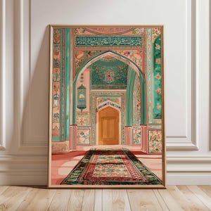 Op de afbeelding: Een ingelijste kunstdruk die een sierlijk interieur toont met bogen, deuren en een patroonkleed. Het kunstwerk gebruikt roze, teal en goud, met ingewikkelde bloemen- en geometrische ontwerpen. De print wordt weergegeven op een houten vloer.