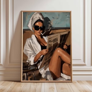 May include: Art print in a wooden frame depicting a woman in a white robe and sunglasses, smoking a cigarette and reading a newspaper. A glass of liquid sits on a side table. The artwork is in a brown wooden frame.