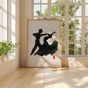 K&ouml;nnte beinhalten: Ein gerahmtes Kunstwerk zeigt ein tanzendes Paar in schwarzer Tinte auf neutralem Hintergrund. Die T&auml;nzer sind als Silhouette dargestellt, wobei das Kleid der Frau flie&szlig;t. Ein kleines rotes Quadrat befindet sich in der unteren rechten Ecke. Das Kunstwerk wird in einem Raum mit nat&uuml;rlichem Licht ausgestellt.