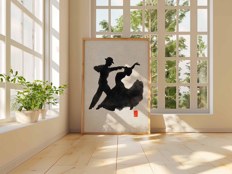 K&ouml;nnte beinhalten: Ein gerahmtes Kunstwerk zeigt ein tanzendes Paar in schwarzer Tinte auf neutralem Hintergrund. Die T&auml;nzer sind als Silhouette dargestellt, wobei das Kleid der Frau flie&szlig;t. Ein kleines rotes Quadrat befindet sich in der unteren rechten Ecke. Das Kunstwerk wird in einem Raum mit nat&uuml;rlichem Licht ausgestellt.