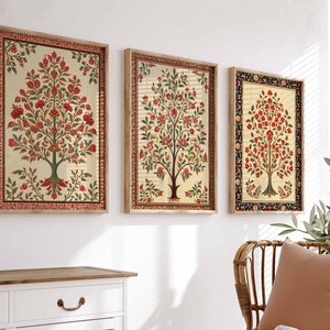 May include: Three framed wall art prints featuring a traditional Indian floral design with a tree motif in shades of red, green, and cream. The frames are a light wood color.