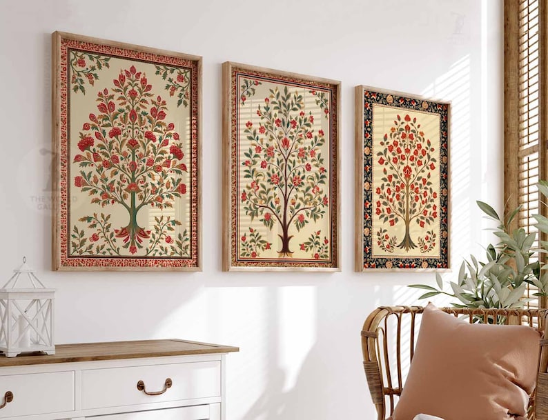 May include: Three framed wall art prints featuring a traditional Indian floral design with a tree motif in shades of red, green, and cream. The frames are a light wood color.