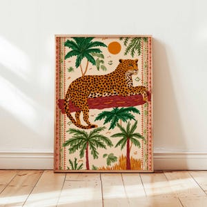 May include: A framed art print depicting a leopard resting on a tree branch, with palm trees and a setting sun. The artwork has a beige background and a decorative border. The leopard has orange and black spots.