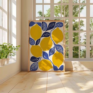 May include: A framed art print featuring a vibrant lemon design. The artwork showcases large yellow lemons with blue leaves against a cream background. The print is displayed in a light-colored wooden frame, adding a touch of nature-inspired decor.