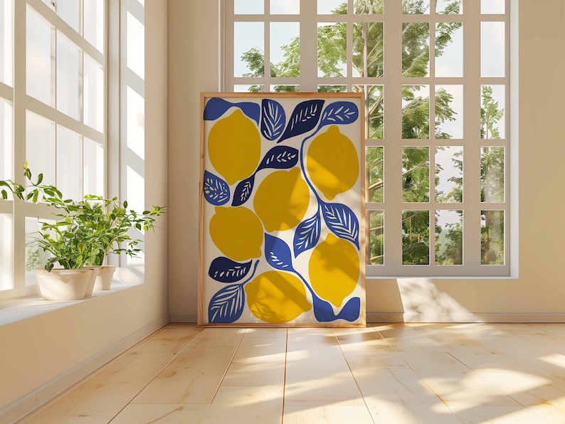 May include: A framed art print featuring a vibrant lemon design. The artwork showcases large yellow lemons with blue leaves against a cream background. The print is displayed in a light-colored wooden frame, adding a touch of nature-inspired decor.