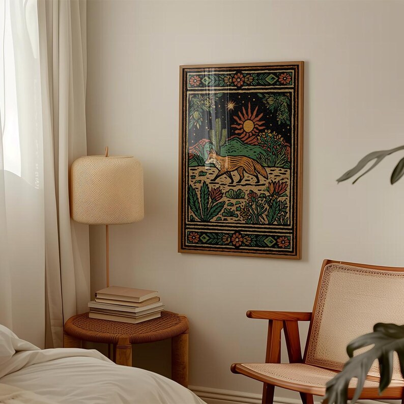 May include: A framed art print featuring a stylized fox in a desert landscape with a sun and cactus. The artwork has a dark background with green, orange, and brown details. The frame is a natural wood color.