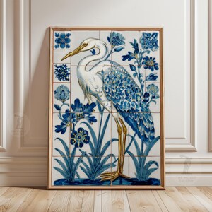 May include: A framed artwork featuring a white heron with blue and gold accents, surrounded by blue floral designs. The artwork is composed of multiple tiles, creating a unique texture. The frame is a warm, natural wood tone.