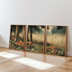 May include: Three framed art prints depicting a tranquil forest landscape. The prints display tall trees, verdant foliage, and striking red-topped mushrooms. The artwork has a vintage style with a natural colour palette, perfect for home decor.
