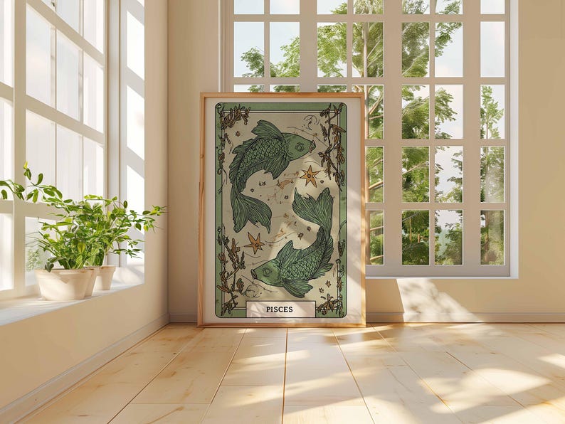 May include: A framed art print featuring a Pisces zodiac illustration. The artwork depicts two green fish swimming in opposite directions, with stars and botanical elements. The print has a light green and beige color palette and is displayed in a room with natural light.