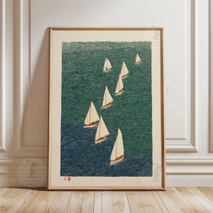 Può includere: Una stampa incorniciata con una flotta di barche a vela su un mare verde-azzurro. Le barche hanno vele bianche e alberi marroni, su uno sfondo d'acqua strutturato. L'opera d'arte è in stile vintage, con una cornice in legno.
