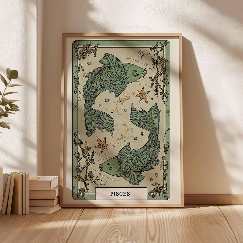 May include: A framed art print featuring two green fish swimming in opposite directions, surrounded by stars and botanical elements. The print has a vintage aesthetic with the word "PISCES" at the bottom. The artwork is in a wooden frame.