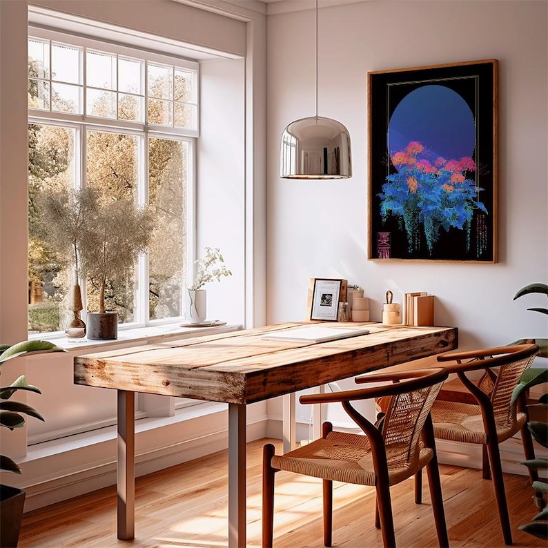 May include: A well-lit room with a large window overlooking a tree-filled landscape. A wooden table with metal legs and two woven chairs are in the foreground. A framed artwork with a blue and floral design hangs on the wall.