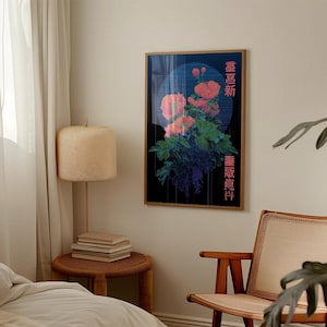 May include: A framed art print featuring a floral arrangement with orange and pink blooms, green leaves, and blue and purple accents against a black background. The print has Japanese text on the right and left sides.