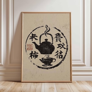 May include: Framed art print with a black ink illustration of a teapot and teacup within a circular design. The design includes Japanese characters and a red stamp, set against a beige background. The print is in a wooden frame.