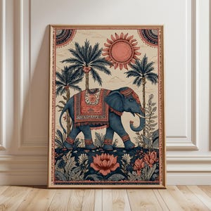 Può includere: Una stampa artistica incorniciata raffigurante un elefante blu con motivi decorativi, ambientato in un paesaggio di palme, fiori e un sole. L'opera d'arte è incorniciata in legno, con una combinazione di colori blu, corallo e beige.