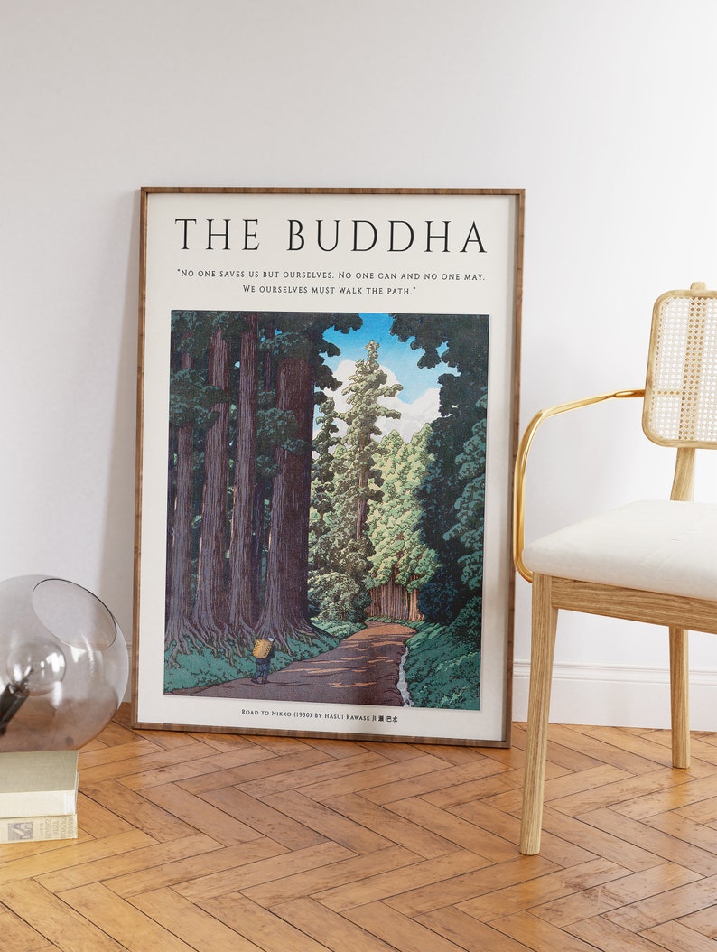 Op de afbeelding: Een ingelijste print van een Japanse houtsnede die een weg door een bos met hoge bomen toont. De print is getiteld "Road to Nikko (1930) by Hakuju Yamakawa" en bevat de quote "Niemand redt ons behalve onszelf. Niemand kan en niemand mag. We moeten zelf de weg bewandelen."
