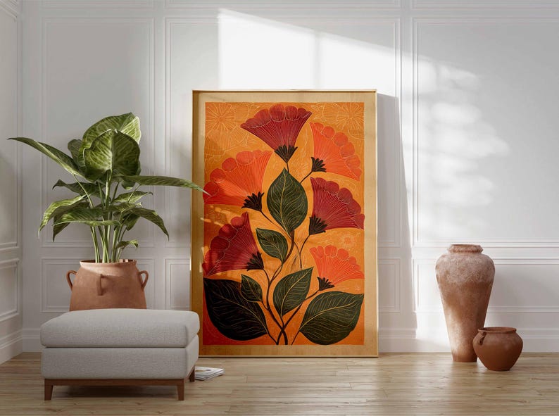 May include: A framed floral art print featuring stylized red and orange flowers with green leaves against an orange background. The artwork is displayed on a wooden floor, next to a potted plant and a gray ottoman. Decorative vases are also present.