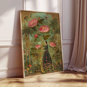 May include: A framed art print featuring a woman in a floral dress amidst a garden scene. The artwork showcases large pink flowers, lush greenery, and birds. The frame is a light wood color, and the overall aesthetic is reminiscent of vintage botanical illustrations.