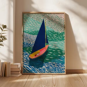 May include: A framed art print depicting a sailboat on the water. The boat has a blue sail and a pink and yellow hull. The water is shown in shades of blue and green, with a textured look. The artwork is in a wooden frame.