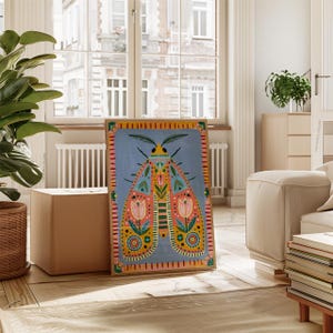 Pode incluir: Uma impress&atilde;o art&iacute;stica emoldurada com um design de tra&ccedil;a colorido. A tra&ccedil;a tem um fundo azul com um padr&atilde;o detalhado de formas florais e geom&eacute;tricas rosa, laranja, amarelo e verde. A obra de arte &eacute; exibida em uma sala clara com uma janela grande.