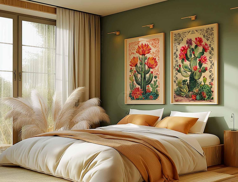 Op de afbeelding: Twee ingelijste botanische prints van cactussen met roze bloemen, hangend aan een groene muur boven een wit bed met oranje en bruine beddengoed.