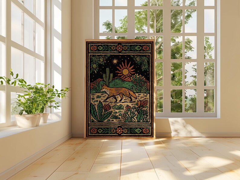 May include: A framed art print featuring a desert landscape with a fox, cactus, and sun. The artwork has a black background with green, orange, and yellow details. The print is displayed in a room with a window and plants.