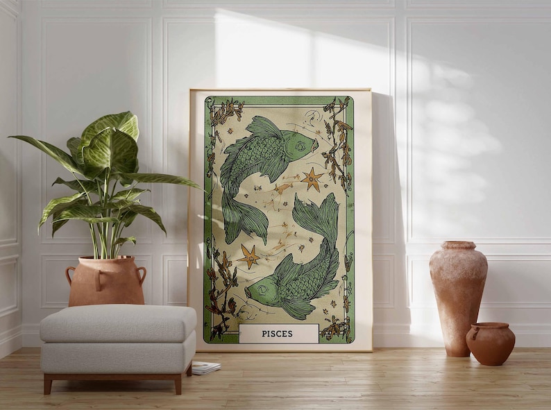 May include: A framed art print featuring two green fish, stars, and botanical elements, labeled "PISCES." The artwork has a vintage aesthetic with a cream-colored background and a green border. The print is displayed on a wooden floor.