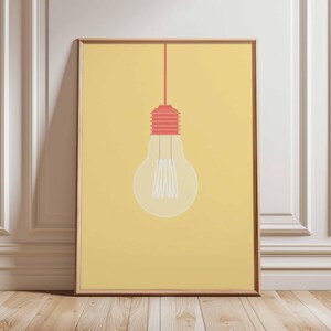 May include: A framed art print featuring a minimalist illustration of a light bulb. The light bulb is transparent with white filaments, a red base, and a red cord against a yellow background. The artwork is in a wooden frame.