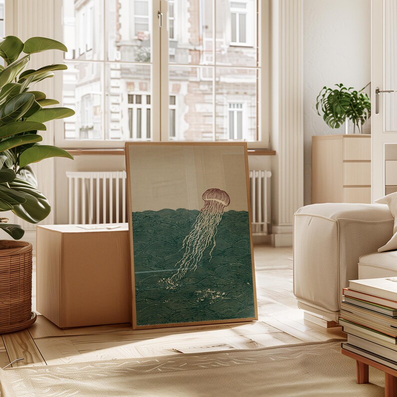May include: A framed art print featuring a jellyfish illustration. The artwork depicts a jellyfish with a brown bell and long, flowing tentacles in a teal ocean. The print is displayed in a light-filled room with a large window.