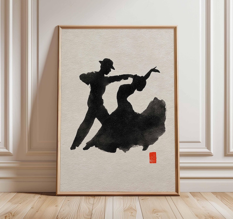 K&ouml;nnte beinhalten: Ein gerahmter Kunstdruck mit einer schwarzen Tintensilhouette eines tanzenden Paares. Der Mann tr&auml;gt einen Hut, und das Kleid der Frau ist ausgestellt. Ein kleines rotes Quadrat befindet sich in der unteren rechten Ecke. Das Kunstwerk ist auf hellem Beige.