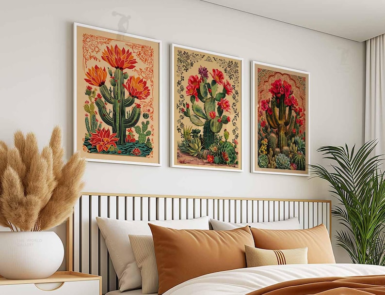 May include: Three framed vintage botanical prints featuring illustrations of red and green cacti with flowers. The prints are displayed on a white wall above a brown headboard with a white and brown bed.
