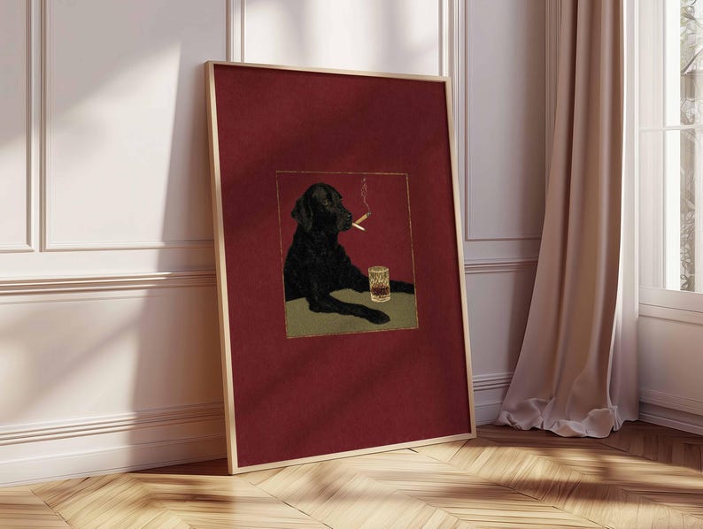 Puede incluir: Impresi&oacute;n art&iacute;stica enmarcada que presenta un Labrador Retriever negro con un cigarrillo encendido y un vaso de whisky. La obra de arte est&aacute; ambientada sobre un fondo rojo oscuro con un marco dorado. El perro se muestra en una pose relajada.