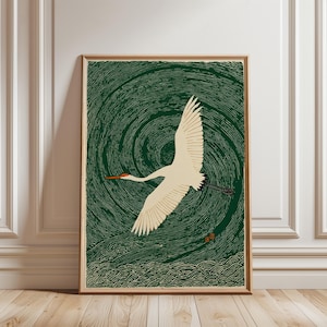 May include: A framed art print depicting a white crane in flight against a swirling green backdrop. The crane has a red beak and black tail feathers. The artwork is in a vintage woodblock print style, with stylized waves at the bottom.