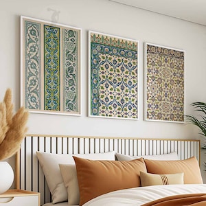 May include: Three framed prints of intricate floral patterns in shades of blue, green, and brown. The prints are hung on a white wall above a bed with a brown headboard.
