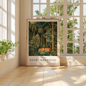 Puede incluir: Una impresi&oacute;n art&iacute;stica enmarcada de "El Sue&ntilde;o" de Henri Rousseau, que muestra un tigre en un bosque verde. La impresi&oacute;n se exhibe en una habitaci&oacute;n luminosa con una ventana y plantas en macetas.