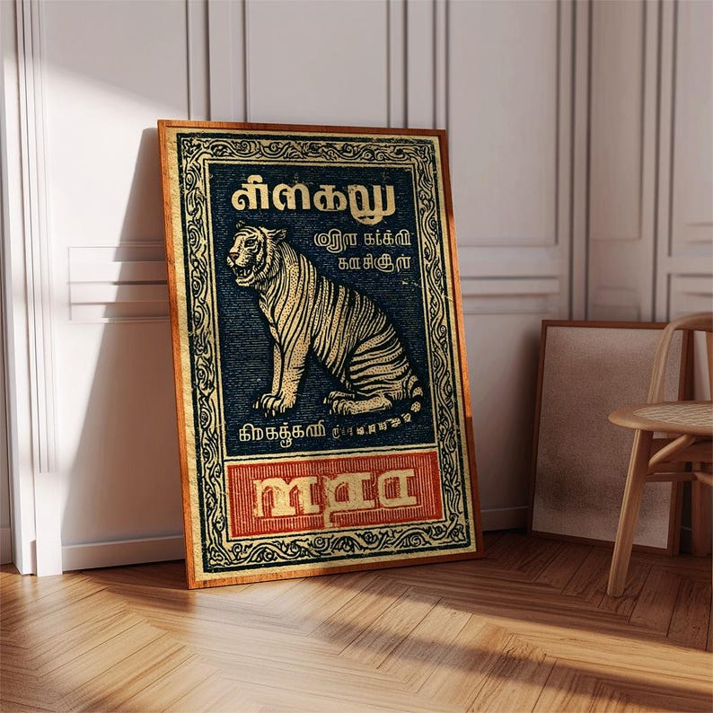 May include: A framed vintage-style poster featuring a tiger illustration. The tiger is depicted in gold against a dark blue background, with text in a foreign language. The frame is a warm brown color, and the poster is leaning against a white wall.