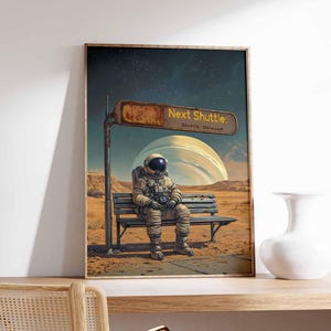 Op de afbeelding: Een digitale kunstprint met een astronaut die op een bankje in een woestijnlandschap zit. Het bord boven het bankje luidt "Next Shuttle: Shuttle Delayed".