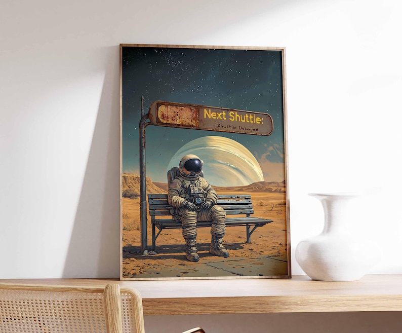 Op de afbeelding: Een digitale kunstprint met een astronaut die op een bankje in een woestijnlandschap zit. Het bord boven het bankje luidt "Next Shuttle: Shuttle Delayed".