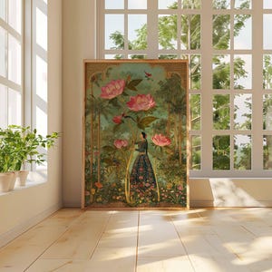 May include: A framed art print featuring a woman in a floral dress amidst large pink flowers and lush greenery. The artwork has a vintage aesthetic, with a wooden frame. The scene is set near a window with natural light.