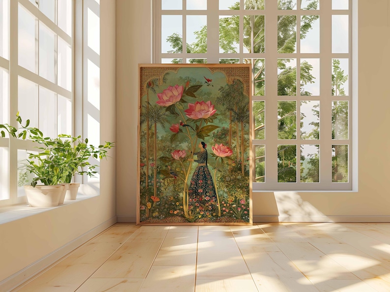 May include: A framed art print featuring a woman in a floral dress amidst large pink flowers and lush greenery. The artwork has a vintage aesthetic, with a wooden frame. The scene is set near a window with natural light.