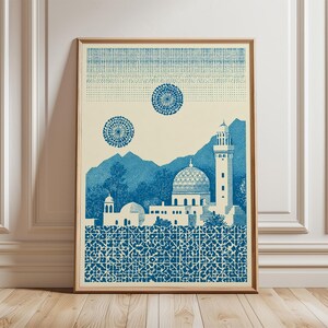 May include: Blue and cream-colored art print featuring a detailed illustration of a Middle Eastern cityscape. The print includes a mosque with a dome and minaret, mountains, and decorative patterns. The artwork is framed in a wooden frame.