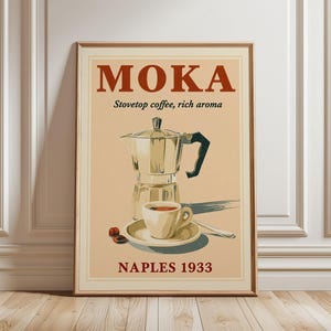 Könnte beinhalten: Ein rechteckiges Wandposter mit hellbeigem Hintergrund, das eine Espressokanne, eine Tasse auf einer Untertasse und zwei Kaffeebohnen zeigt. Der Text lautet MOKA, Stovetop coffee, rich aroma und NAPLES 1933 in roter und schwarzer Schrift.