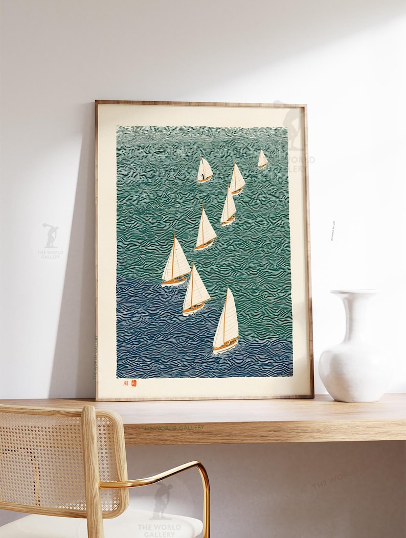 May include: A framed print featuring a stylized depiction of sailboats on a textured ocean. The artwork uses shades of blue and green to represent the water, with white sails catching the wind. The print is displayed on a wooden shelf with a white vase.