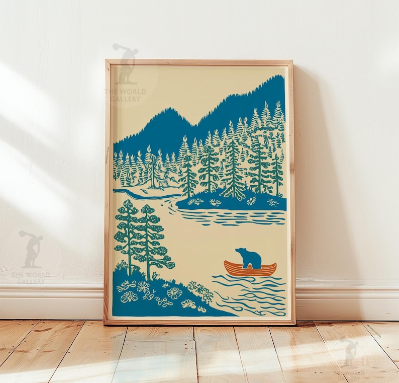 May include: A framed art print featuring a serene landscape with a teal forest, mountains, and a river. A bear is in an orange canoe. The artwork has a vintage aesthetic, with a cream-colored background and a wooden frame.